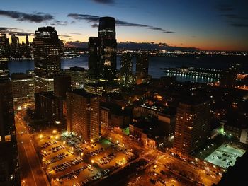 Illuminated cityscape against sky at dusk