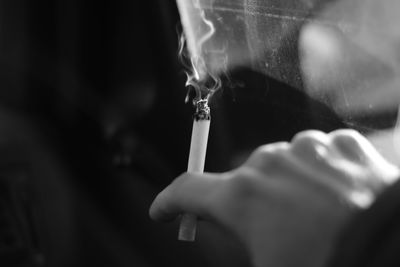 Close-up of hand holding cigarette