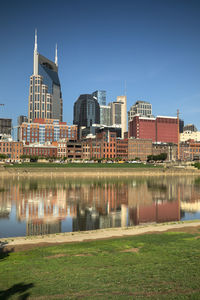 Reflection of buildings in river against blue sky