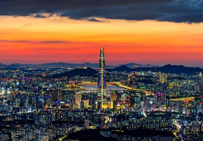 High angle view of illuminated cityscape against sky during sunset