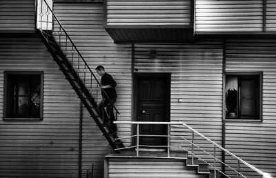 Side view of man climbing steps outside house