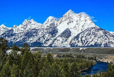 Scenic view of snowcapped mountains against blue sky