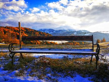 Scenic view of field by lake against sky during winter