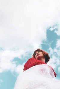 Low angle view of woman standing against sky