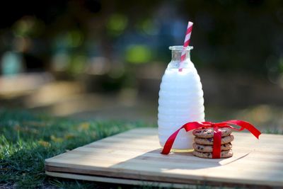 Cookies with ribbon tied and milk bottle on cutting board