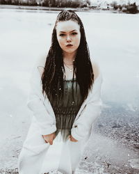 Portrait of young woman standing in water