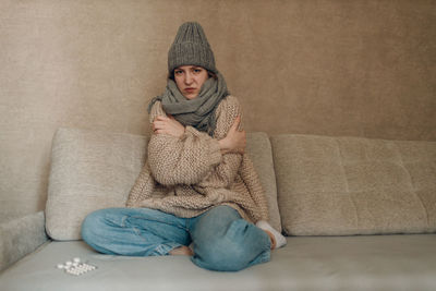 Portrait of young woman sitting on sofa at home