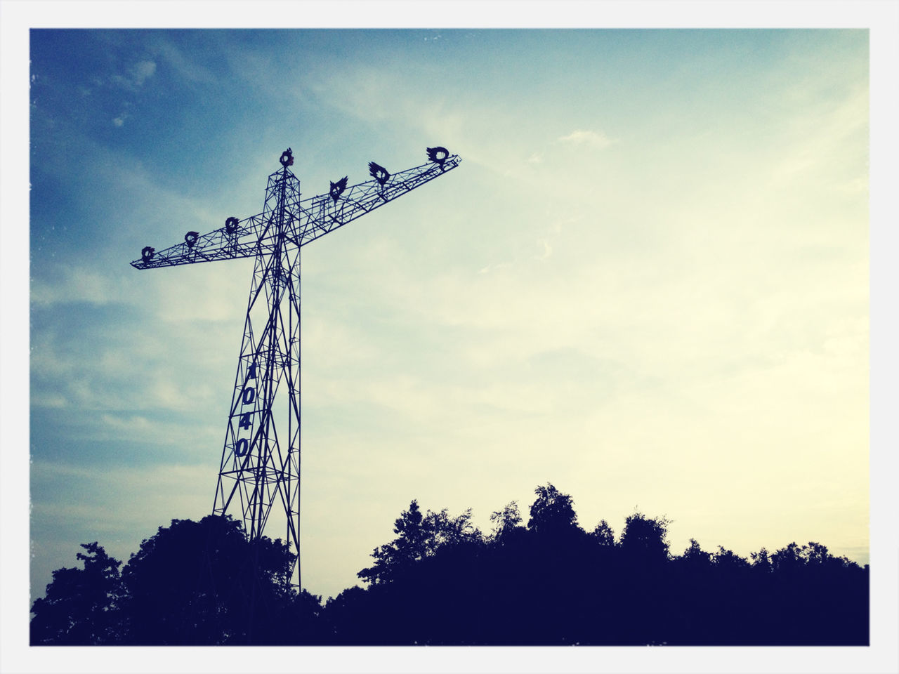 low angle view, sky, silhouette, communication, fuel and power generation, tall - high, cloud - sky, construction site, technology, crane - construction machinery, auto post production filter, environmental conservation, tree, outdoors, dusk, transfer print, built structure, cloud, no people, development