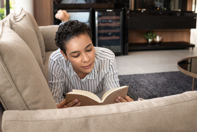 Side view of young woman reading book