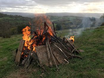 High angle view of bonfire on landscape against sky