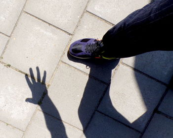 Low section of man standing on sidewalk