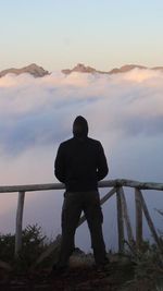 Man standing on mountain against sky during sunset