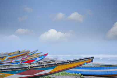 Low angle view of boats moored on beach against sky