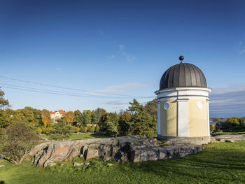 Built structure on field against sky