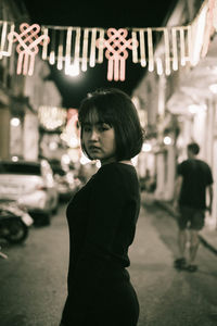 Rear view of a boy looking at camera at night