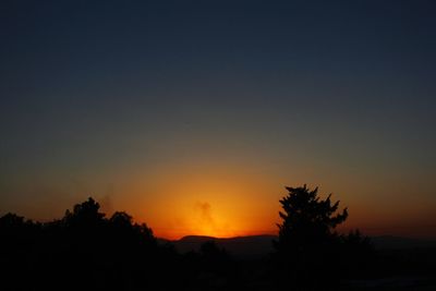 Silhouette trees against sky during sunset