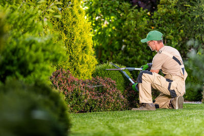 Gardener using pruning sheers at yard