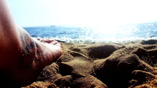 Low section of man relaxing on beach