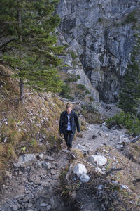 High angle view of woman walking on trail in forest