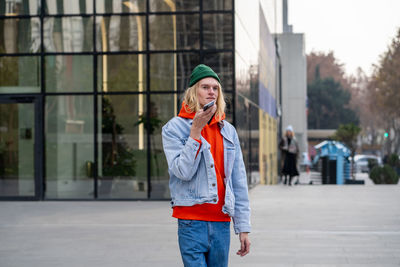 Young man using mobile phone in city