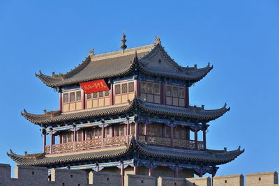 Low angle view of temple building against clear blue sky