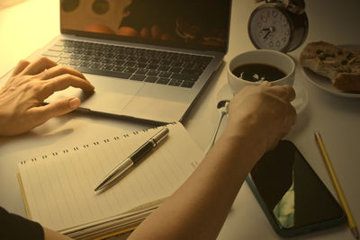 Midsection of man using laptop on table