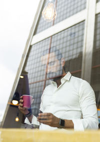 Man holding coffee cup on table