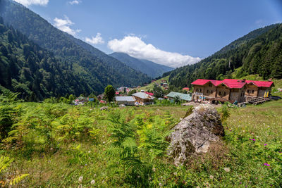 Scenic view of houses and mountains against sky