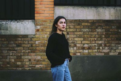 Portrait of woman standing against building