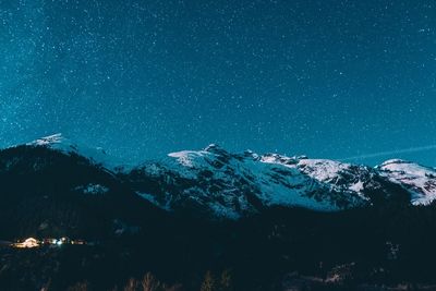 Scenic view of snowcapped mountains against sky at night