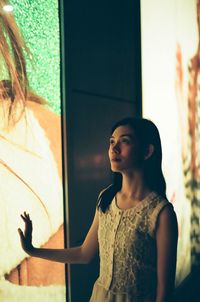 Portrait of young woman standing at home