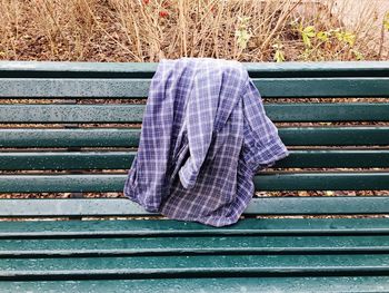 Close-up of plaid shirt over a bench 