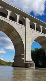 Arch bridge over river against sky