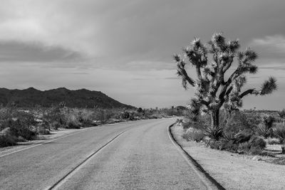 Empty road along landscape and against sky