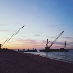 Cranes at commercial dock against sky during sunset in norfolk, va