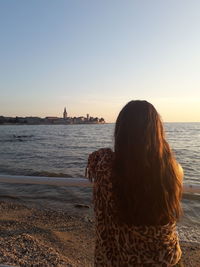 Rear view of woman looking at sea against sky