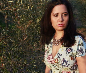 Portrait of beautiful woman standing against plants