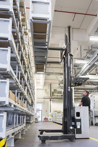 Worker operating forklift in factory warehouse