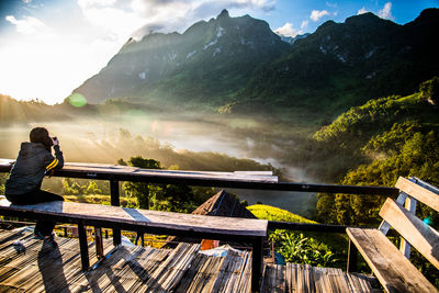 Man looking at view of mountains against sky