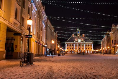 Illuminated city against sky at night during winter