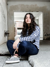 Portrait of beautiful young woman sitting indoor