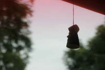 Low angle view of shoes hanging against the sky