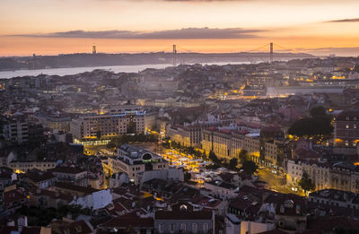 High angle view of illuminated buildings in city during sunset