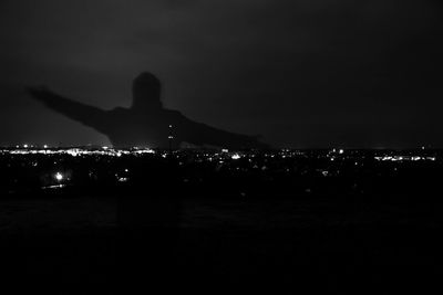 Illuminated cityscape against sky at night