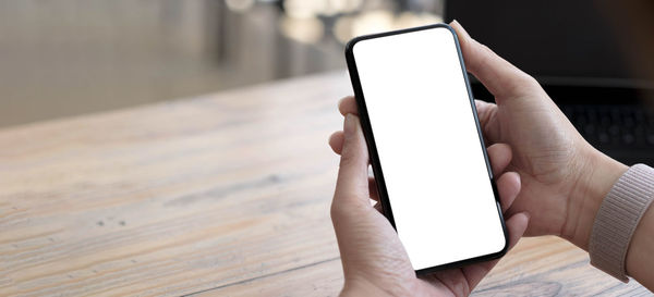 Close-up of hand holding mobile phone