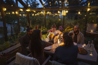 Friends having meal in greenhouse