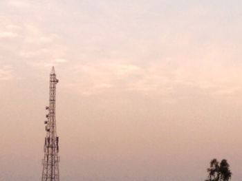 Low angle view of communications tower against sky during sunset