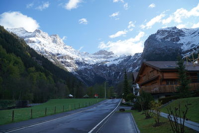 Road amidst snowcapped mountains against sky