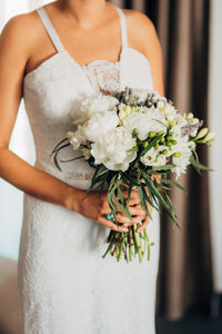 Midsection of woman holding flower bouquet