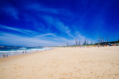 Scenic view of beach against blue sky